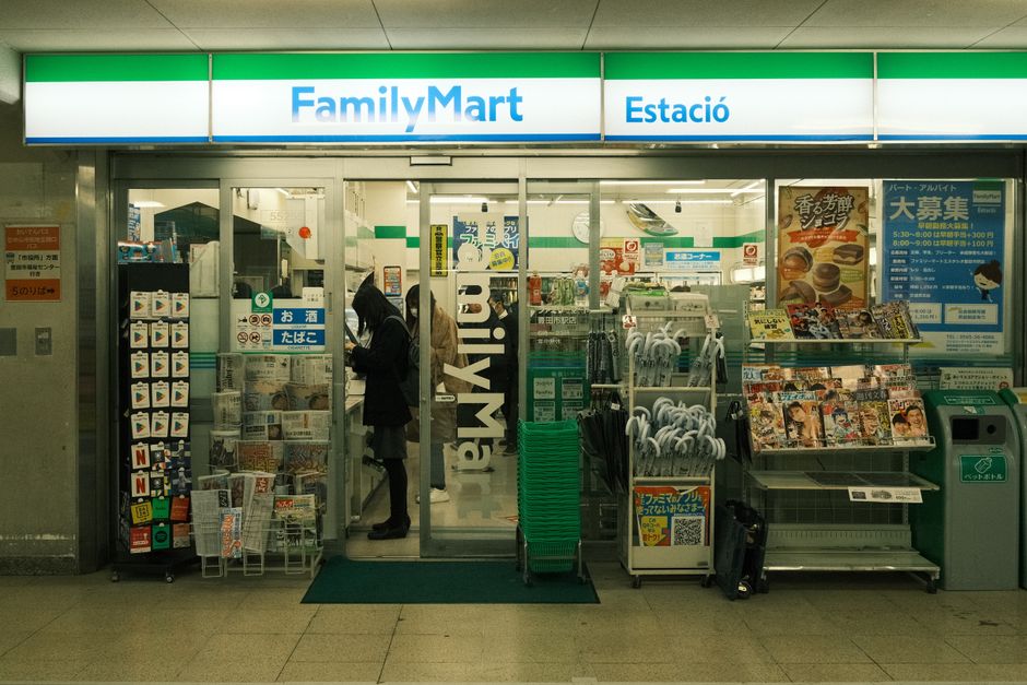 日本のトヨタにあるファミリーマートの入口に商品と人々がいます。