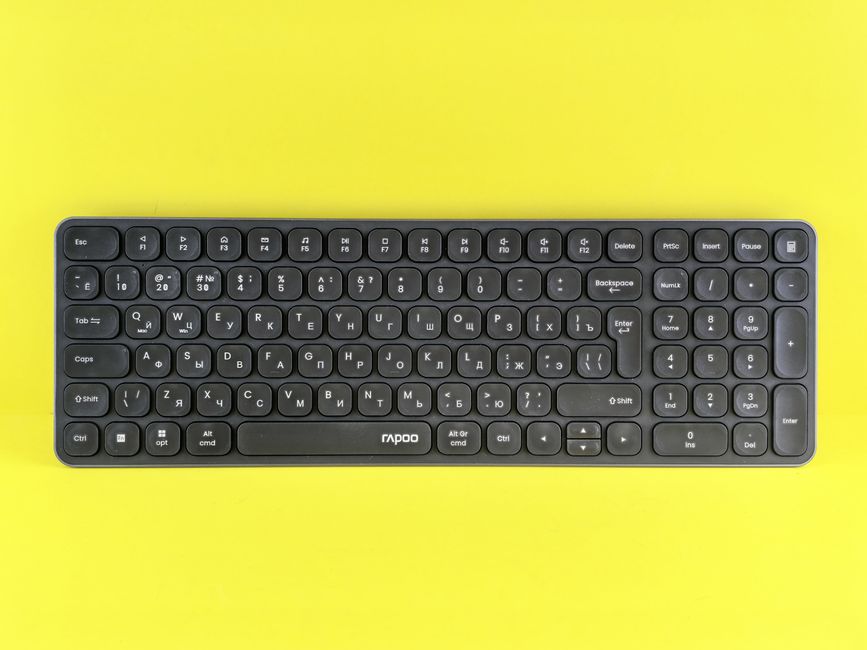 明るい黄色の背景にキリル文字が印刷された黒のワイヤレス キーボード。