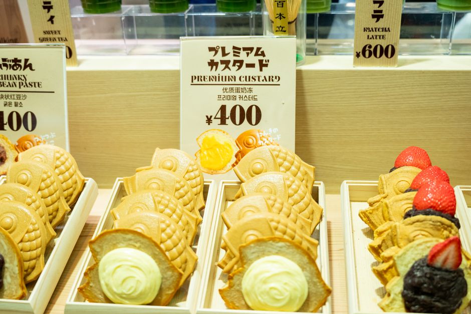 日本のお店に並ぶ、カスタードクリームとあんこが入った美味しそうなたい焼き。
