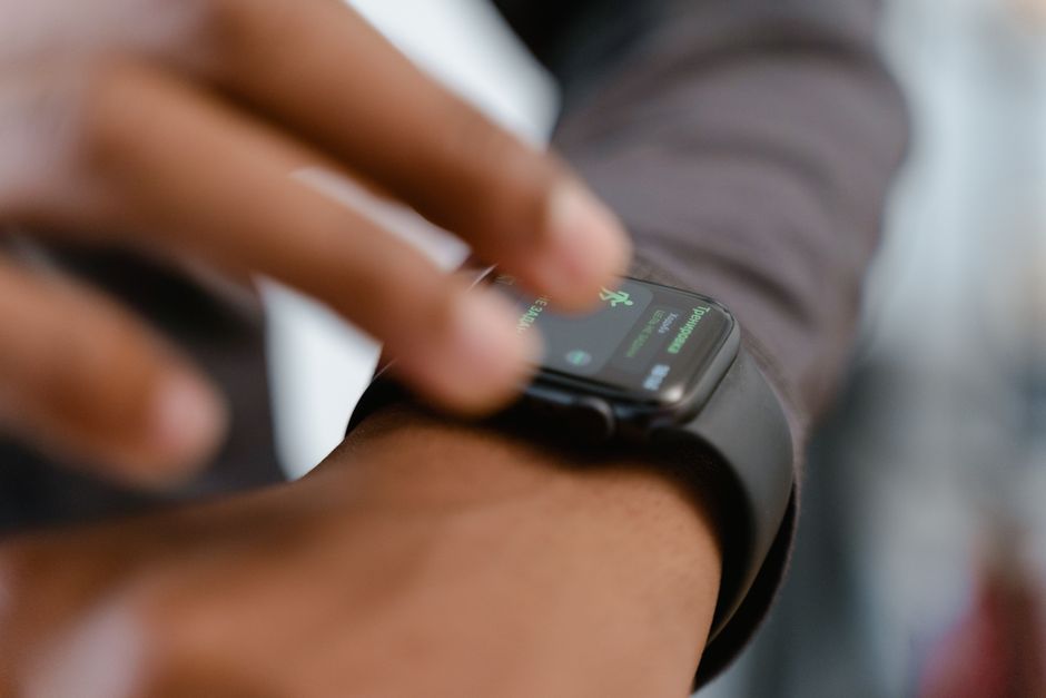 スマートウォッチと対話している人を詳細に示した画像で、フィットネストラッキング機能を強調しています。
