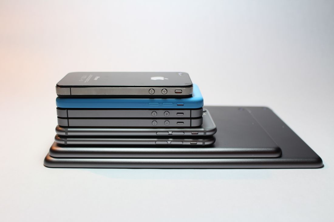 洗練されたデザインを持つモダンなスマートフォンとタブレットが積み重なっています。完璧なテクノロジーの背景。