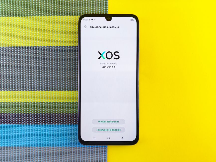 カラフルな背景のスマートフォンが、Androidに基づいたXOSバージョンの更新を表示しています。