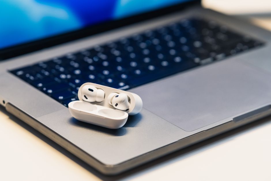 ノートPCの上に置かれたワイヤレスイヤホン(Sport オープン Earbudsと純正イヤホン比較のイメージ)